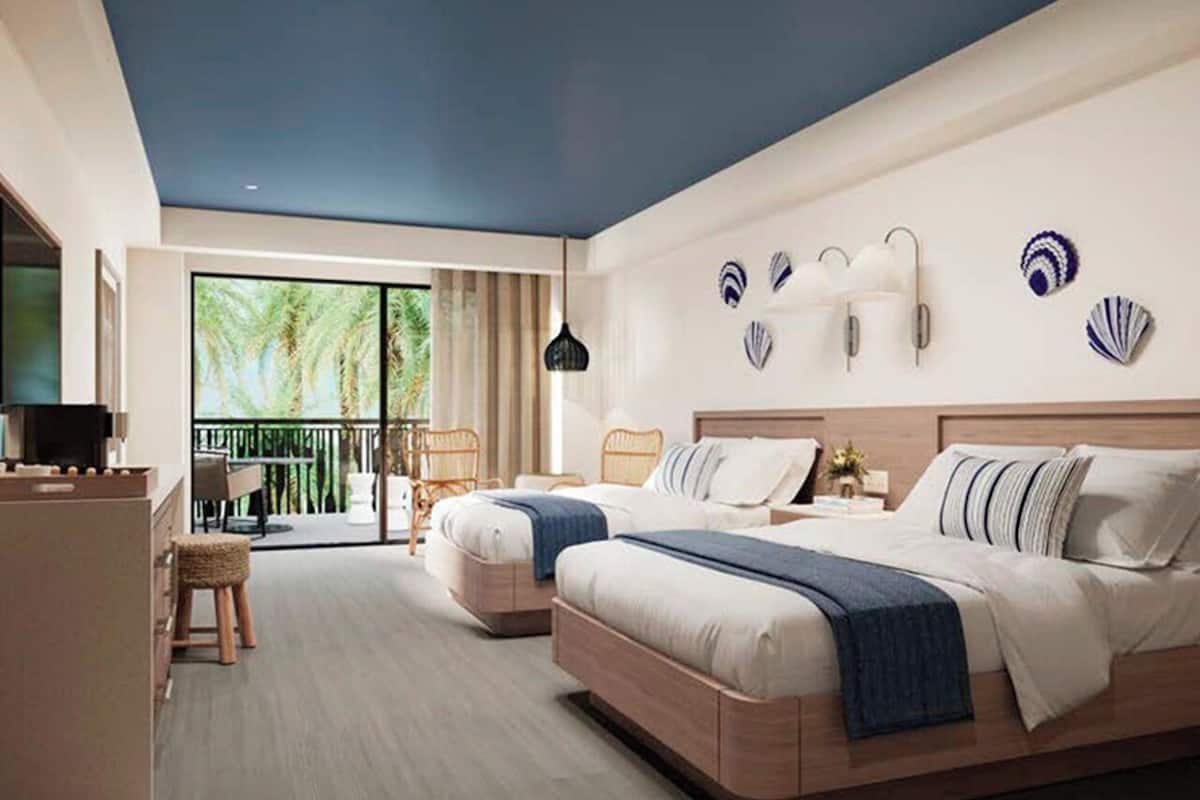 Una habitación de hotel moderna con dos camas, un balcón y un comedor.