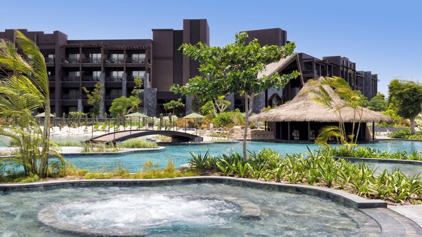 Un resort con piscina, jacuzzi y un puente.