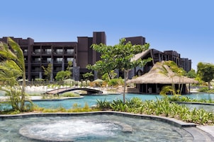 Un resort con piscina, jacuzzi y un puente.