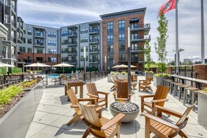 A rooftop patio with outdoor seating, a pool, and a view of the surrounding buildings. - Landing | Incredible 1BD, Pool, Gym (Knoxville)