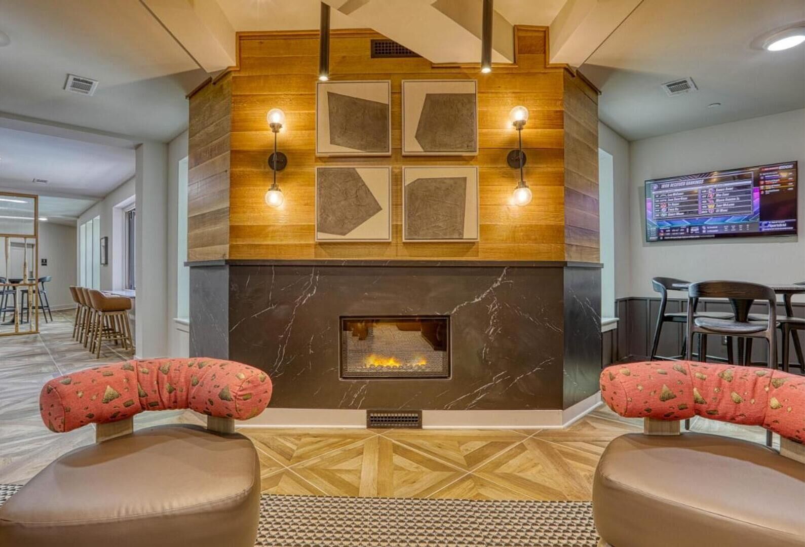A lobby with a fireplace, seating area, and a television screen displaying a menu.