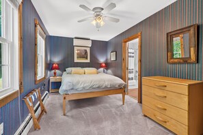 Un dormitorio con cama, cómoda y ventilador de techo.