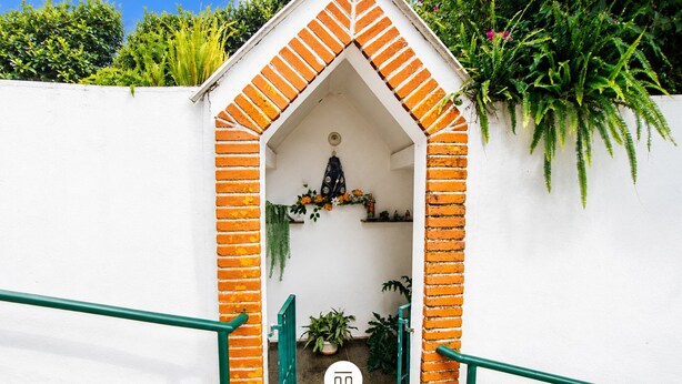 A white building with a brick archway entrance, a green railing, and a logo with 'MULTI TEMPORADA' text. - Chácara 3 Poderes Piscina - 60 pessoas (Guararema)