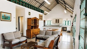 A spacious living area with a high ceiling, a wooden cabinet, and a dining table. - Chácara 3 Poderes Piscina - 60 pessoas (Guararema)