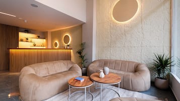 A modern lobby with sofas, a reception desk, and a circular wall feature.