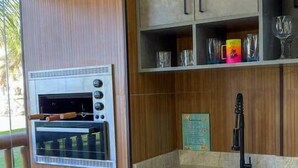 Una cucina moderna con forno a incasso, dispenser per l'acqua e lavandino.