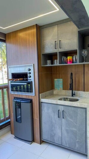 Une cuisine moderne dotée d’un four encastré, d’un distributeur d’eau et d’un évier.