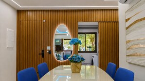 Una sala conferenze con un lungo tavolo, sedie blu e un vaso con fiori blu.