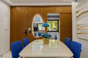 Une salle de conférence avec une longue table, des chaises bleues et un vase rempli de fleurs bleues.