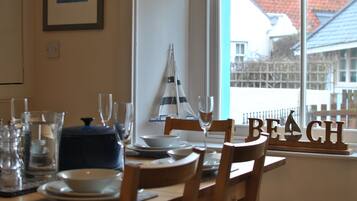 A dining table set with plates, glasses, and a decorative sailboat.
