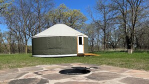 A yurt with a stone fire pit in front. - North Star Yurt at Whiterock Conservancy (Coon Rapids)