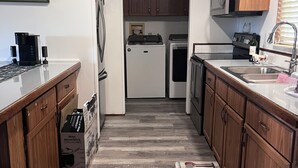 A kitchen with wooden cabinets, a microwave, a refrigerator, and a coffee maker. - Gator Camp 2.7 off the rim of Lake Okeechobee Buckhead Ridge (Okeechobee)