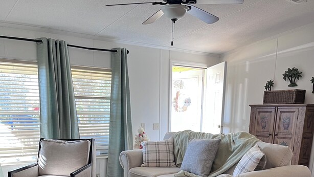 A living room with a sofa, a chair, and a floor lamp. - Gator Camp 2.7 off the rim of Lake Okeechobee Buckhead Ridge (Okeechobee)