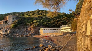 A coastal building with a stone facade, a balcony, and a view of the sea and greenery. - Sandra and Lucia's home in an oasis of peace (Quercianella)