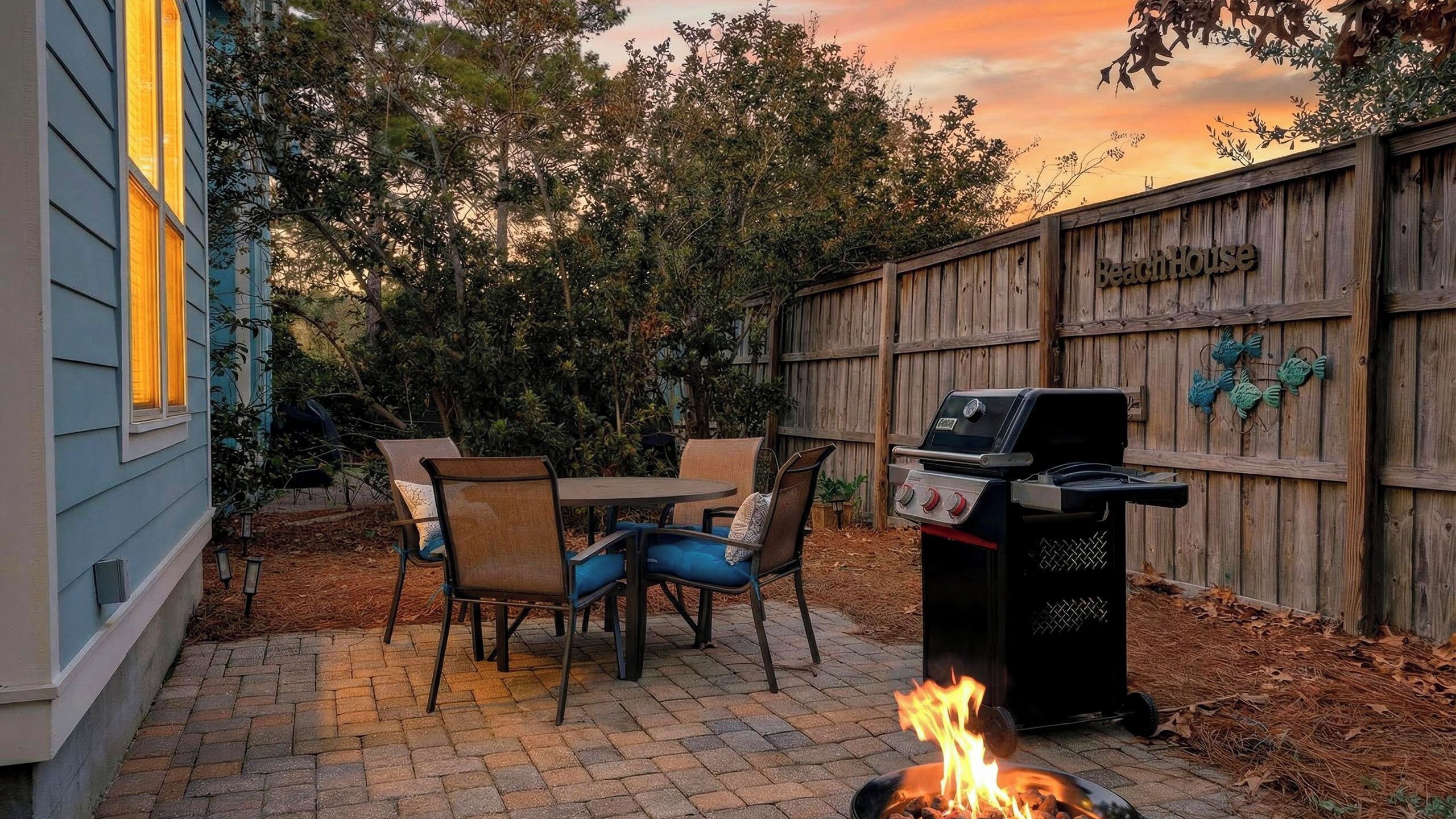 A backyard with a barbecue grill, a fire pit, and a wooden fence labeled 'BeachHouse'.