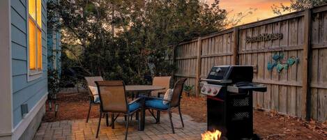 A backyard with a barbecue grill, a fire pit, and a wooden fence labeled 'BeachHouse'.