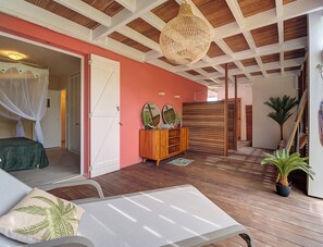 Une pièce comprenant un lit, une armoire en bois, un luminaire suspendu et une plante en pot.
