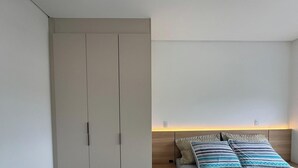 A bedroom with a bed, a wardrobe, and a nightstand. - Sampaio's House - Gov. Celso Ramos - SC (Governador Celso Ramos)