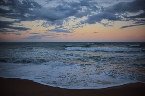 Una playa con olas y un cielo nublado.