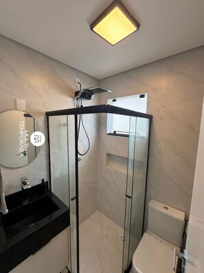 A modern bathroom with a glass-enclosed shower, a black sink, a toilet, and a mirror. - Sampaio's House - Gov. Celso Ramos - SC (Governador Celso Ramos)