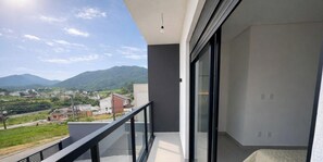 A balcony with a view of a mountainous landscape and a town below. - Sampaio's House - Gov. Celso Ramos - SC (Governador Celso Ramos)