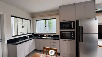 Premium House | Private kitchen | Fridge, microwave, cookware/dishes/utensils, dining tables