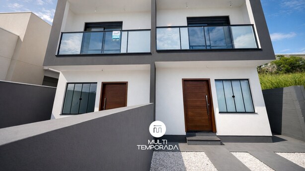 A modern two-story house with a balcony, large windows, and a flat roof. - Sampaio's House - Gov. Celso Ramos - SC (Governador Celso Ramos)