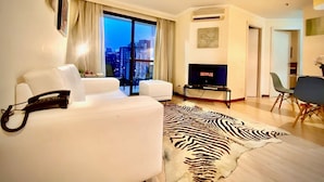 A modern living room with a white sofa, a flat-screen TV, and a zebra print rug. - World Class Stay - Vila Olímpia (São Paulo)
