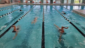 Une piscine avec des couloirs délimités par des lignes noires et blanches.