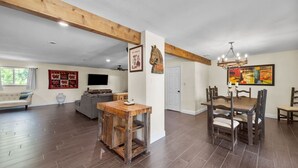 A spacious living room with a sofa, TV, and a dining area with a wooden table and chairs. - Bexar Charming 3-bedroom MidTerm (Arlington)
