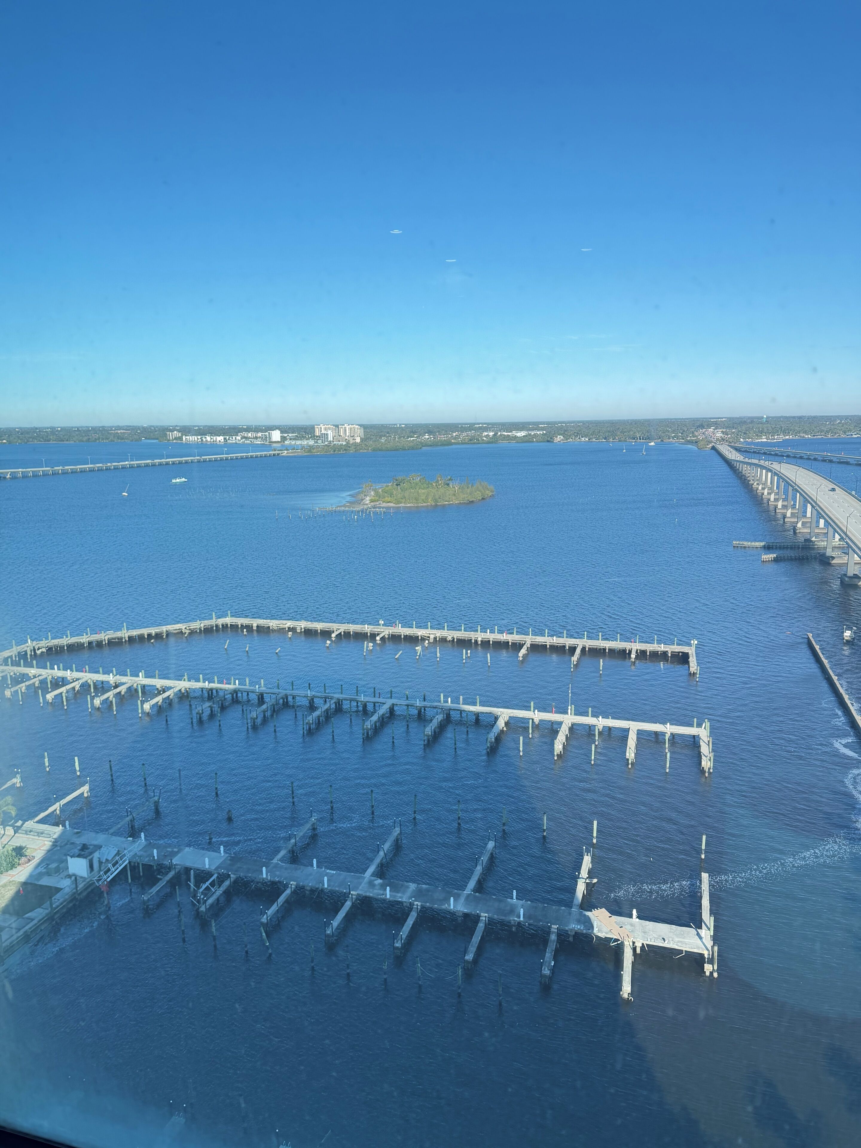 A coastal area with a large body of water, a pier, and a small island.
