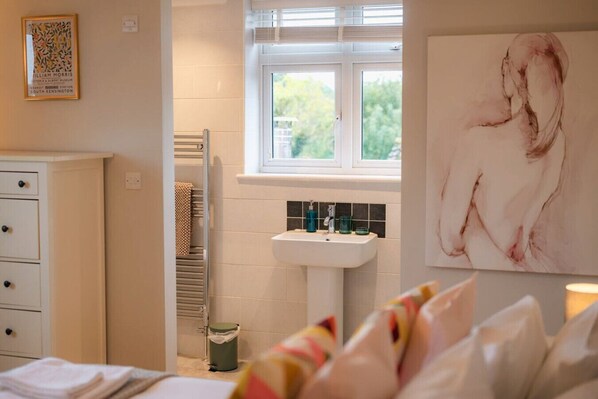 A bathroom with a white sink, a towel rack, and a window.