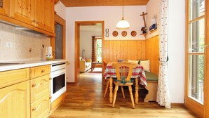 A wooden interior with a kitchen, dining area, and a cozy seating space. - Landhaus Albrecht - Holiday Apartment 01 - with 2 terraces and fireplace (50 m²) (Mittenwald)