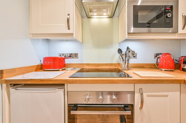 A compact kitchen with a microwave, toaster, and coffee maker. - Muntham Apartment 6 (Torquay)