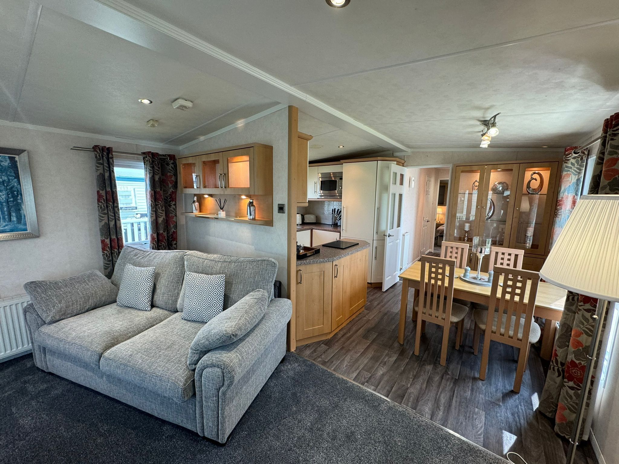 A compact living space with a sofa, dining table, and kitchenette.