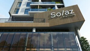 Ein hohes Gebäude mit einem Schild, auf dem 'Solaz Smart Living' steht.