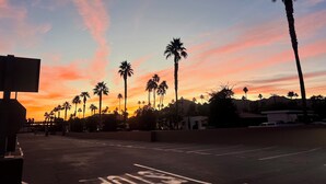 Ein Parkplatz mit Palmen und einem Sonnenuntergangshimmel.