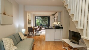 A modern living room with a sofa, a dining area, and a kitchen. - Harbourside (Weymouth)