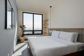Ein modernes Schlafzimmer mit großem Fenster, einem Bett, einer Topfpflanze und eingebauten Regalen.