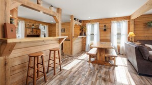 Ein Holzblockhaus mit Küche, Bar und Sitzgelegenheit.
