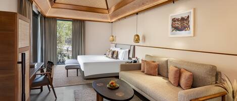 A modern hotel room with a large bed, a sofa, a desk, and a dining table.