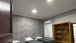 A hotel room with two single beds, a wooden wardrobe, and a small desk. - Arbo Belém Quartos padrão Anfitrião 360 (Belém)