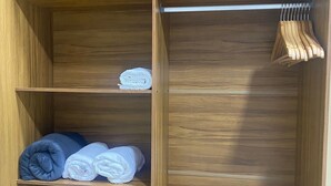 A wooden wardrobe with multiple shelves and a hanging rod. - Arbo Belém Quartos padrão Anfitrião 360 (Belém)