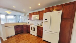 A kitchen with wooden cabinets, a white refrigerator, a microwave, an oven, and a dishwasher. - 1 Bed 1 bath Lakefront Apartment in Lake Hopatcong, NJ w/ lake access and kayaks (Jefferson)