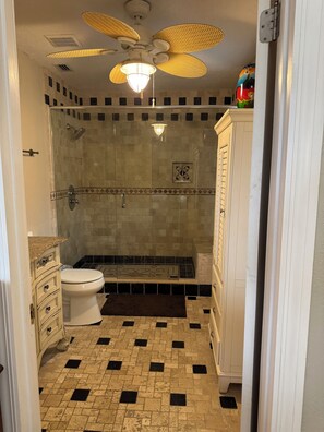 Ein Badezimmer mit Dusche, Toilette und Waschtisch.