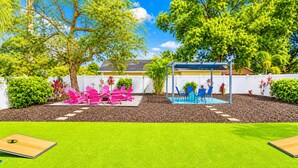 A backyard with a patio area, outdoor furniture, and a covered seating area.