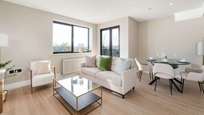 Een moderne woonkamer met een bank, salontafel en eethoek.