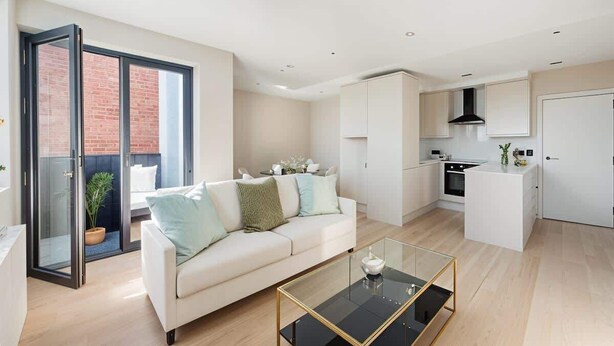 Een modern appartement met een woonkamer, keuken en een schuifdeur naar een balkon.