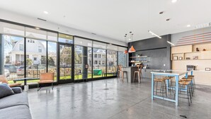 A spacious modern kitchen with a large island, bar stools, and a view of the outside. - 1BR Retreat in Uptown |Walkable | Gym (Minneapolis)
