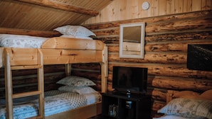 Une cabine équipée de lits superposés, d’un téléviseur et d’un miroir mural.